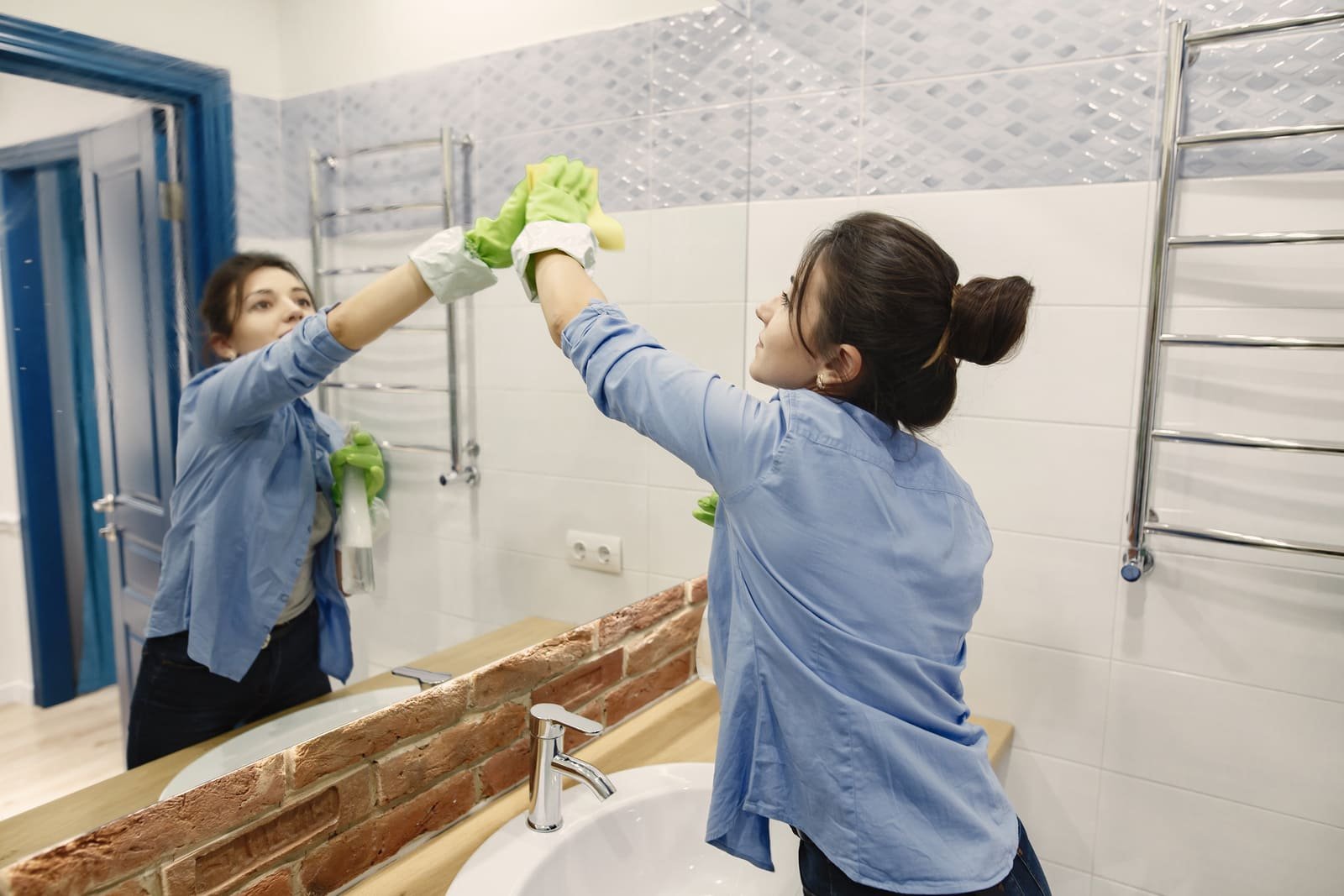 housewife-woking-home-lady-blue-shirt-woman-bathroom low-angle-view-senior-woman-wiping-glass-table-with-spray Residential Cleaning Services Orange Park