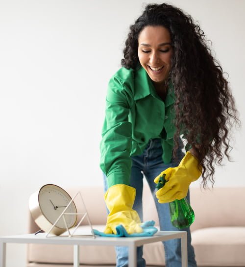 happy-cleaner-lady-cleaning-and-dusting-table-at-h-2022-01-18-23-17-49-utc.jpg