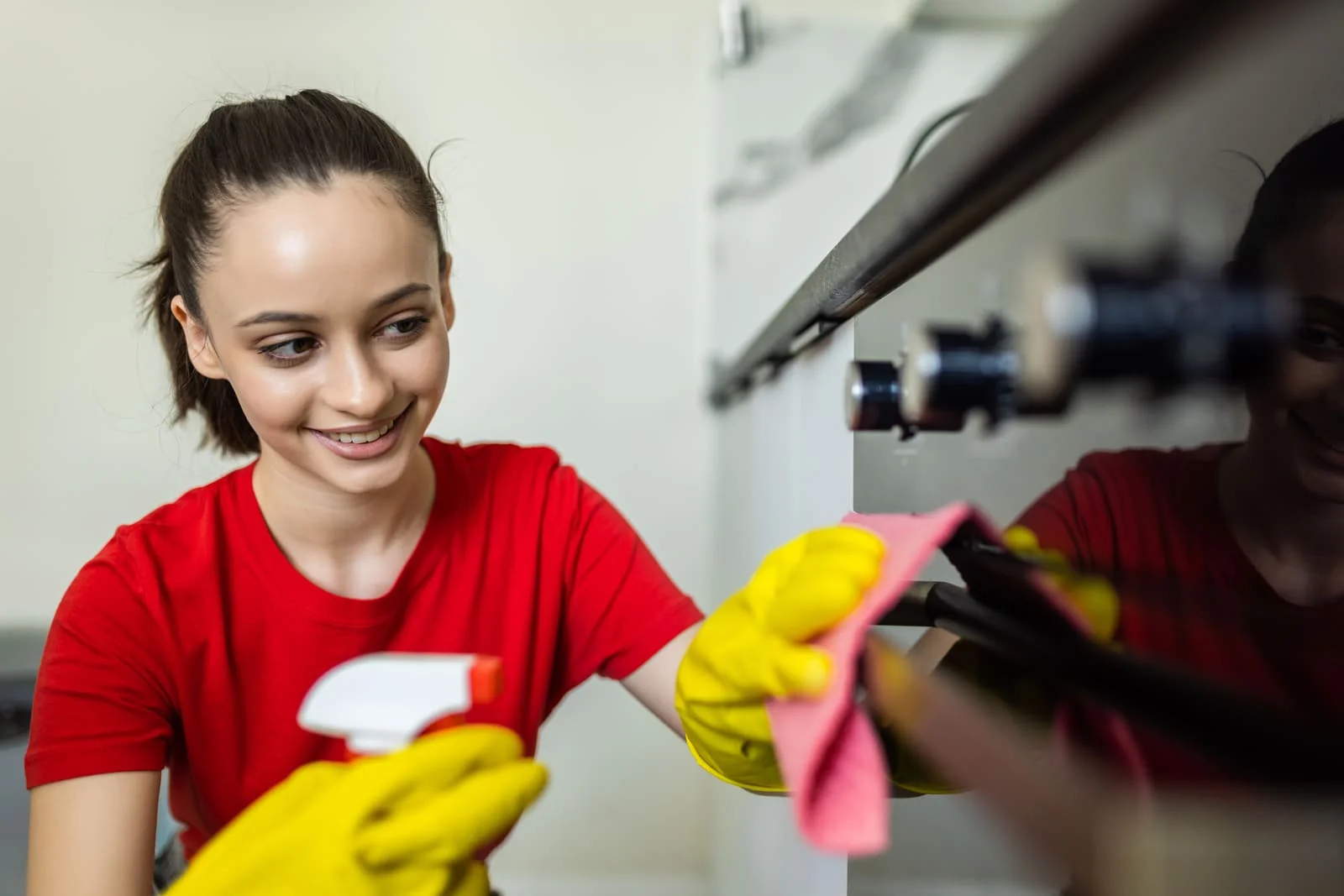 happy-woman-with-bottle-spray-cleanser-cleaning-oven-home-kitchen Professional House Cleaning in Orange Park FL